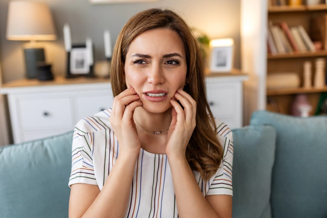 A young woman with a toothache needing same-day emergency dental care in St. Albert